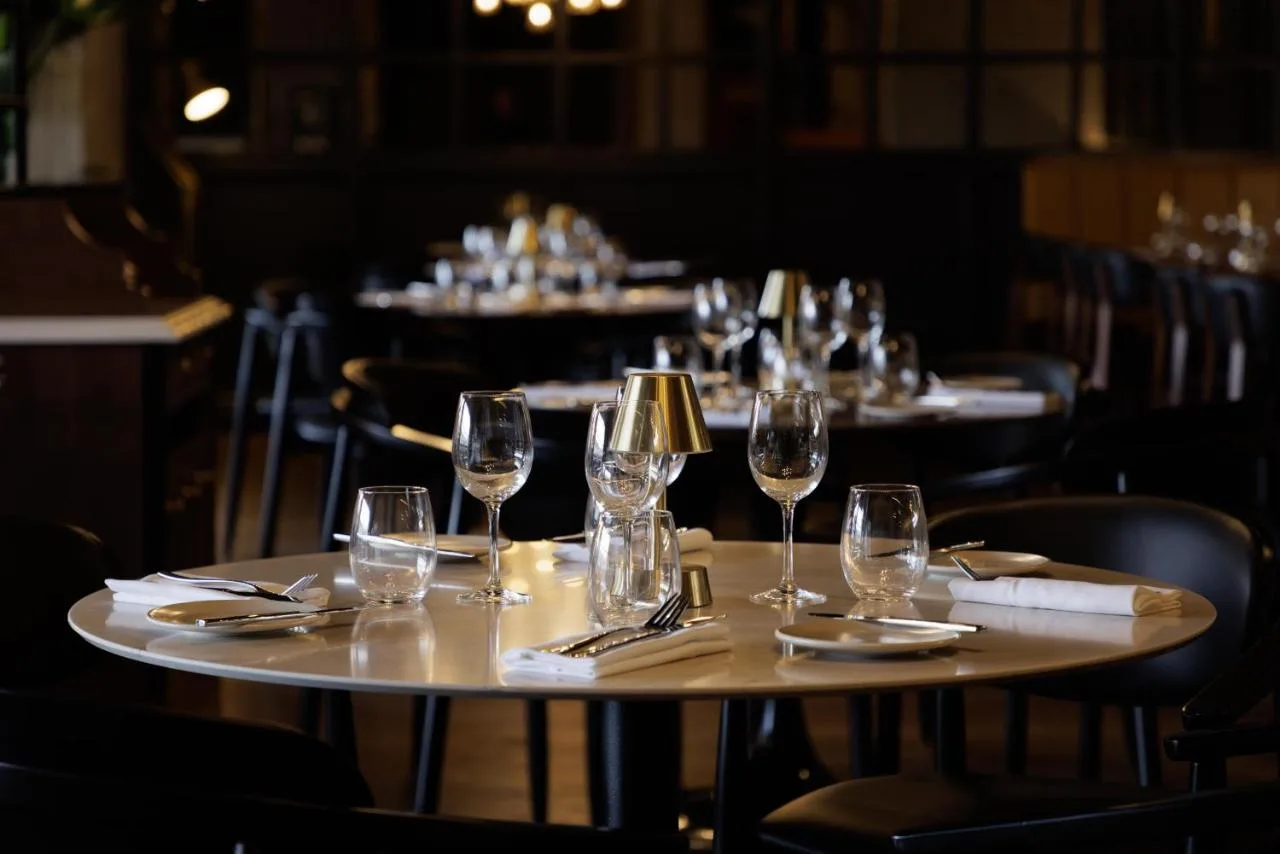a group of tables with wine glasses and napkins at DoubleTree by Hilton Bath in Bath